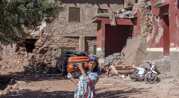 epa10863871 A girl walks among the rubble of damaged buildings at the earthquake-affected village of Tinmel, south of Marrakesh, Morocco, 16 September 2023. The 6.8-magnitude earthquake struck central Morocco late September 08, killing nearly 3,000 people and damaging buildings from villages and towns in the Atlas Mountains to Marrakesh, according to a report issued by the country's Ministry of Interior.  EPA/JALAL MORCHIDI