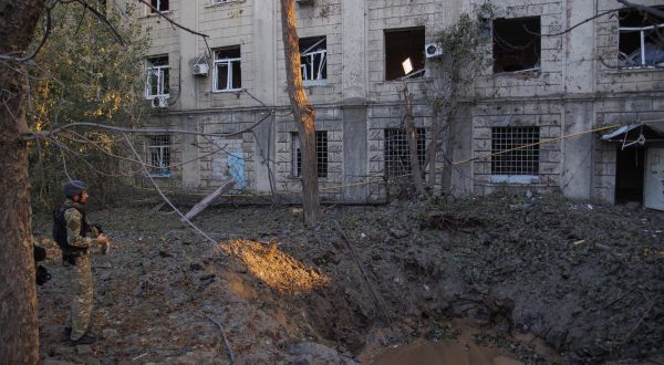 epa10874058 A serviceman stands near the shelling hole after missiles hit in Kharkiv, Ukraine, 21 September 2023. Ukraine recorded 43 rocket attacks overnight, 36 of which were shot down, the Ukrainian Air Force said. A civilian infrastructure object was damaged in Kharkiv as a result of the missile attack. At least two people were injured in Kharkiv as Ukrainian Emergency Service reported.  EPA/YAKIV LIASHENKO