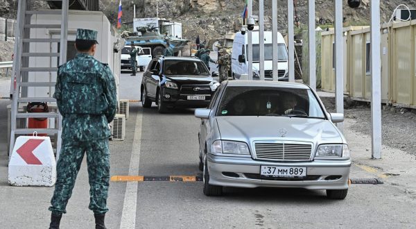 epa10882044 Azeri servicemen stand guard as ethnic Armenians leave Nagorno-Karabakh through a checkpoint on the entrance of the Lachinsky corridor, which connects the Nagorno-Karabakh region with Armenia, in Lachin, Azerbaijan, 25 September 2023. Azerbaijan on 19 September 2023 launched a brief military offensive on the contested region of Nagorno-Karabakh, a breakaway enclave that is home to some 120,000 ethnic Armenians. The Armenian government announced the evacuation of about 3,000 local residents from the region following the ceasefire agreed on 20 September 2023, as Azerbaijan opened all checkpoints with Armenia for the unimpeded exit of civilians from the territory of Nagorno-Karabakh. Russian peacekeepers escorted convoys of civilians from Nagorno-Karabakh leaving for Armenia, the Russian Ministry of Defense reported.  EPA/ROMAN ISMAYILOV