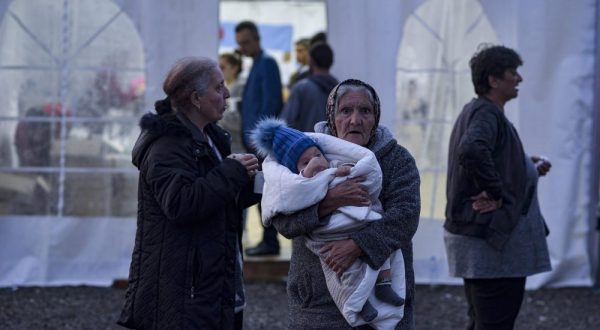 epa10883071 An elderly woman holding an infant waits as ethnic Armenians from Nagorno-Karabakh arrive to a registration center of the Armenian Ministry of Foreign Affairs, near the border town of Kornidzor, Armenia, 25 September 2023. Azerbaijan on 19 September 2023 launched a brief military offensive on the contested region of Nagorno-Karabakh, a breakaway enclave that is home to some 120,000 ethnic Armenians. Following a ceasefire agreed on 20 September 2023, Azerbaijan opened all checkpoints with Armenia for the unimpeded exit of civilians from the disputed territory. The Armenian government announced the evacuation of more than 6,500 local residents from Nagorno-Karabakh, and a humanitarian center has been set up in the village of Kornidzor near the so-called Lachin corridor, the main route between Armenia and the breakaway region. Russian peacekeepers escorted convoys with civilians leaving Nagorno-Karabakh for Armenia, the Russian defense ministry said.  EPA/NAREK ALEKSANYAN
