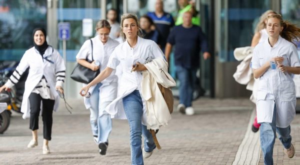 epaselect epa10887856 Medical staff leave the Erasmus MC Rotterdam hospital on Rochussenstraat, which has been cordoned off after two shooting incidents in Rotterdam, Netherlands, 28 September 2023. An unknown person wearing combat clothing shot at people first in an apartment and after in the hospital, the police announced.  EPA/BAS CZERWINSKI