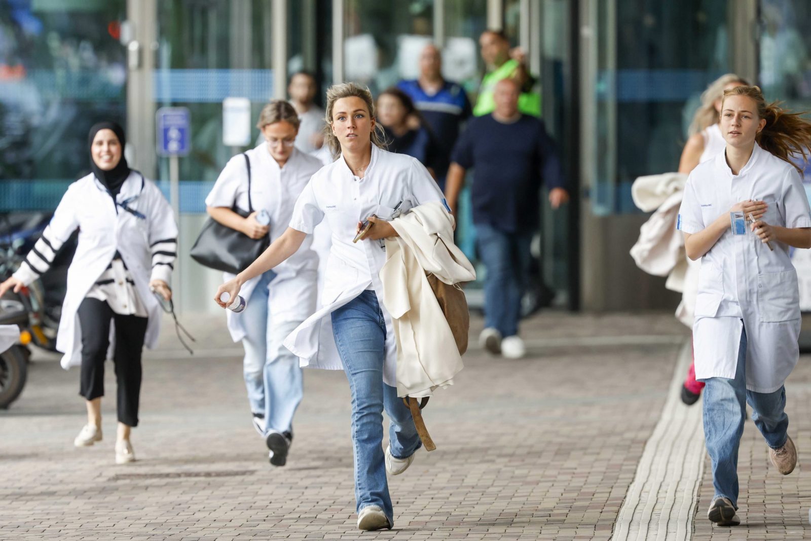 epaselect epa10887856 Medical staff leave the Erasmus MC Rotterdam hospital on Rochussenstraat, which has been cordoned off after two shooting incidents in Rotterdam, Netherlands, 28 September 2023. An unknown person wearing combat clothing shot at people first in an apartment and after in the hospital, the police announced.  EPA/BAS CZERWINSKI