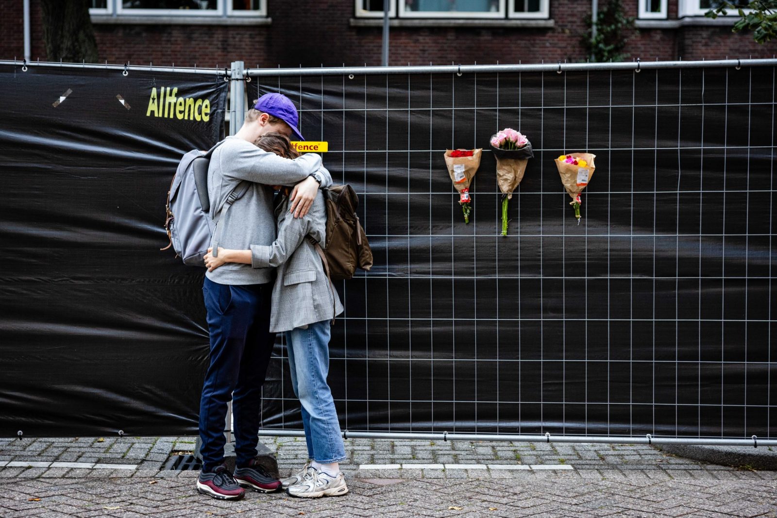 epa10889049 People react next to flowers left at the building on Heiman Dullaertplein in Rotterdam, The Netherlands, 29 September 2023, where a 32-year-old man shot a 39-year-old woman and her 14-year-old daughter on 28 September. The perpetrator shot a 43-year-old man in a classroom of the Erasmus Medical Center. The three victims have died.  The suspect is in Police custody.  EPA/JEFFREY GROENEWEG