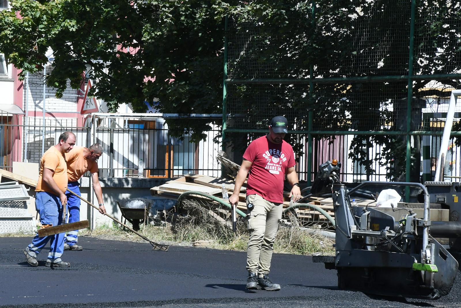 02.09.2023.,Sisak - Radnici Cesta Sisak asfaltiraju sportske terene Gimnazije Sisak koja ce nakon detaljne obnove u potresu unistene zgrade, u ponedjeljak ponovo otvoriti svoja vrata ucenicima.  Photo: Nikola Cutuk/PIXSELL