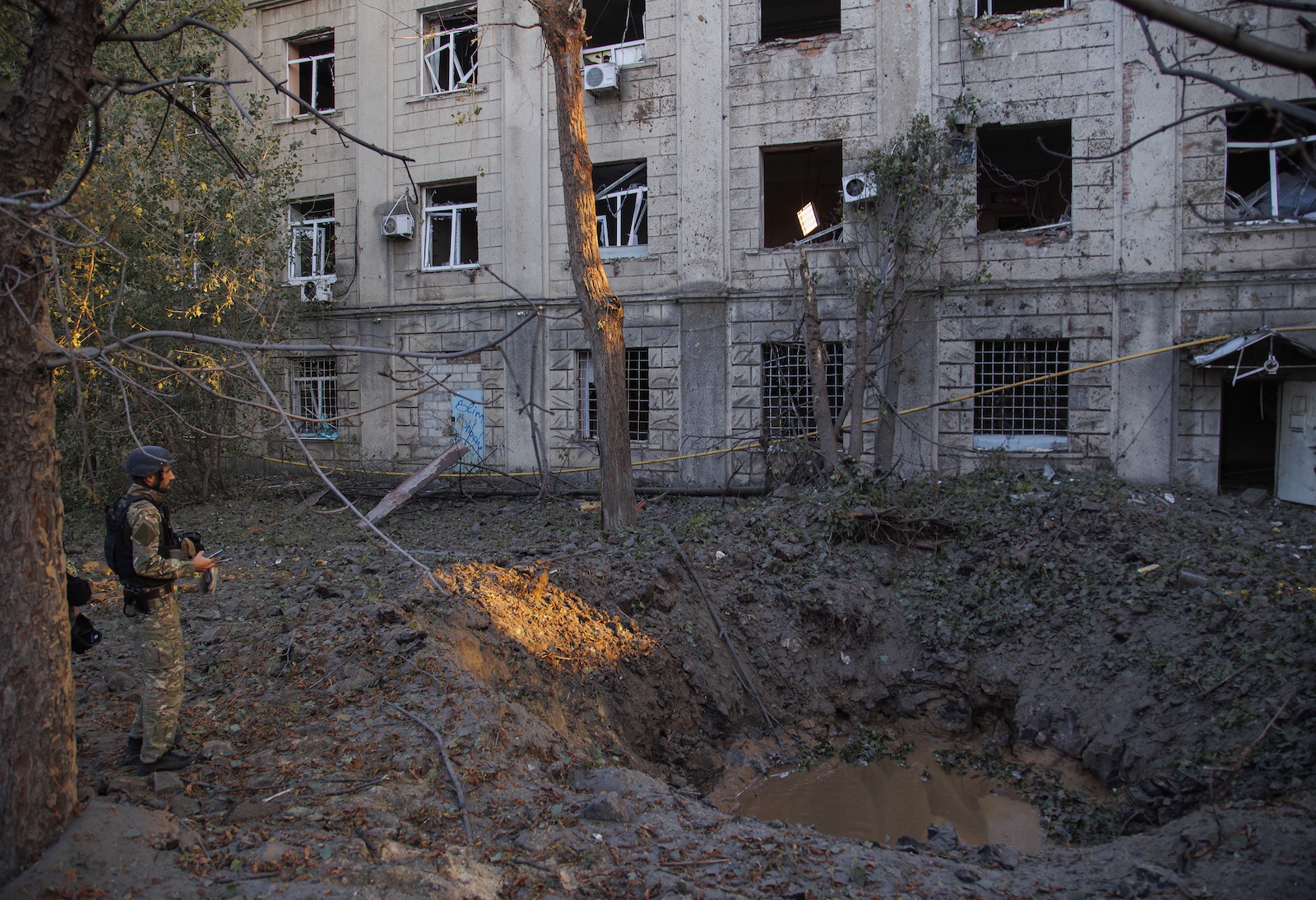 epa10874058 A serviceman stands near the shelling hole after missiles hit in Kharkiv, Ukraine, 21 September 2023. Ukraine recorded 43 rocket attacks overnight, 36 of which were shot down, the Ukrainian Air Force said. A civilian infrastructure object was damaged in Kharkiv as a result of the missile attack. At least two people were injured in Kharkiv as Ukrainian Emergency Service reported.  EPA/YAKIV LIASHENKO