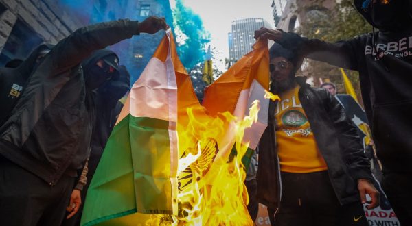 epa10883115 People burn an Indian flag during a protest the killing of Hardeep Singh Nijjar, a Sikh leader who was shot and killed earlier this year, at the Consulate General of India in Vancouver, British Columbia, Canada, on 25 September 2023. Earlier this week Canadian Prime Minister Justin Trudeau accused agents of the government of India of carrying out the killing of Nijjar in June, an accusation that has raised diplomatic tensions between the two countries.  EPA/ETHAN CAIRNS