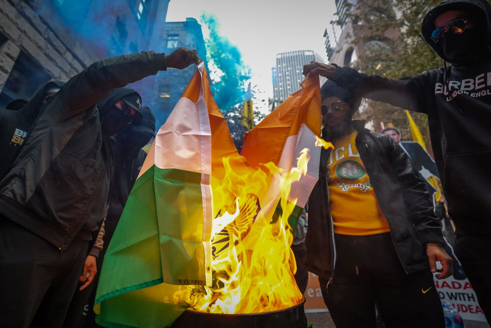 epa10883115 People burn an Indian flag during a protest the killing of Hardeep Singh Nijjar, a Sikh leader who was shot and killed earlier this year, at the Consulate General of India in Vancouver, British Columbia, Canada, on 25 September 2023. Earlier this week Canadian Prime Minister Justin Trudeau accused agents of the government of India of carrying out the killing of Nijjar in June, an accusation that has raised diplomatic tensions between the two countries.  EPA/ETHAN CAIRNS