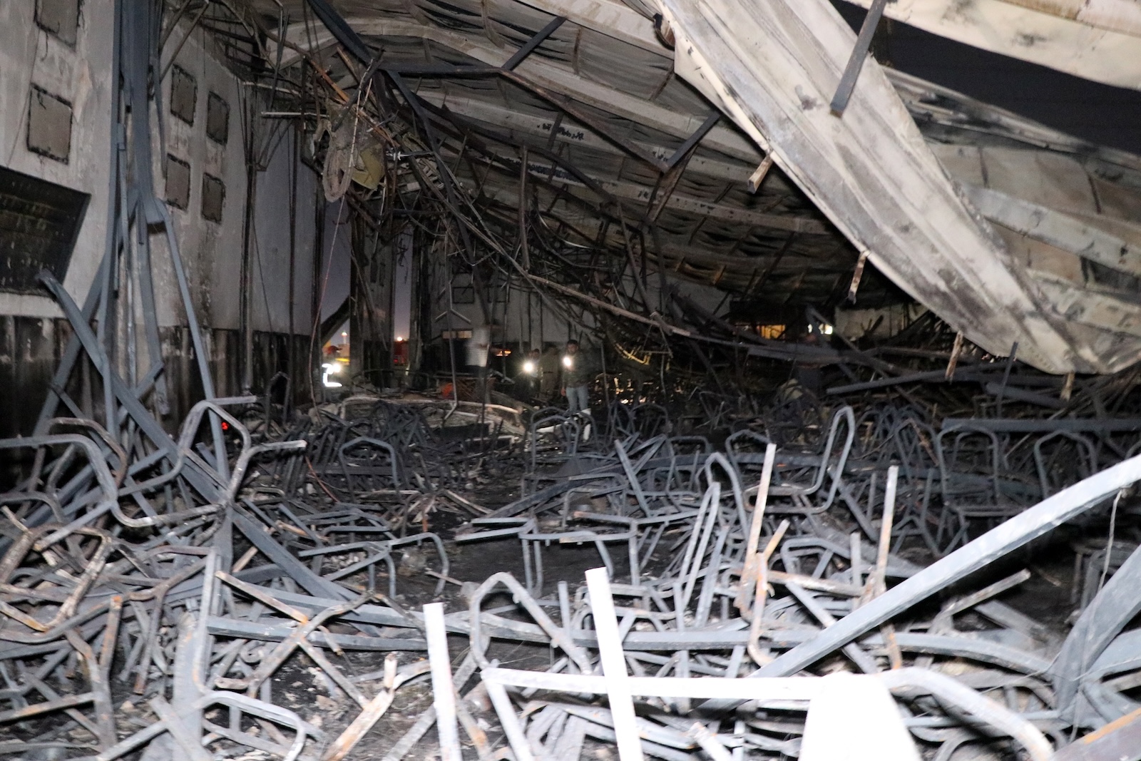 epaselect epa10885151 Iraqi security men inspect the scene of a fire that broke out at a wedding hall in Hamdaniya, in Iraq's Nineveh province, north of Iraq, 27 September 2023. More than 100 people died and at least 150 are injured after a fire during a Christian wedding celebration in Iraq's Nineveh province.  EPA/MOHAMAD SAIF