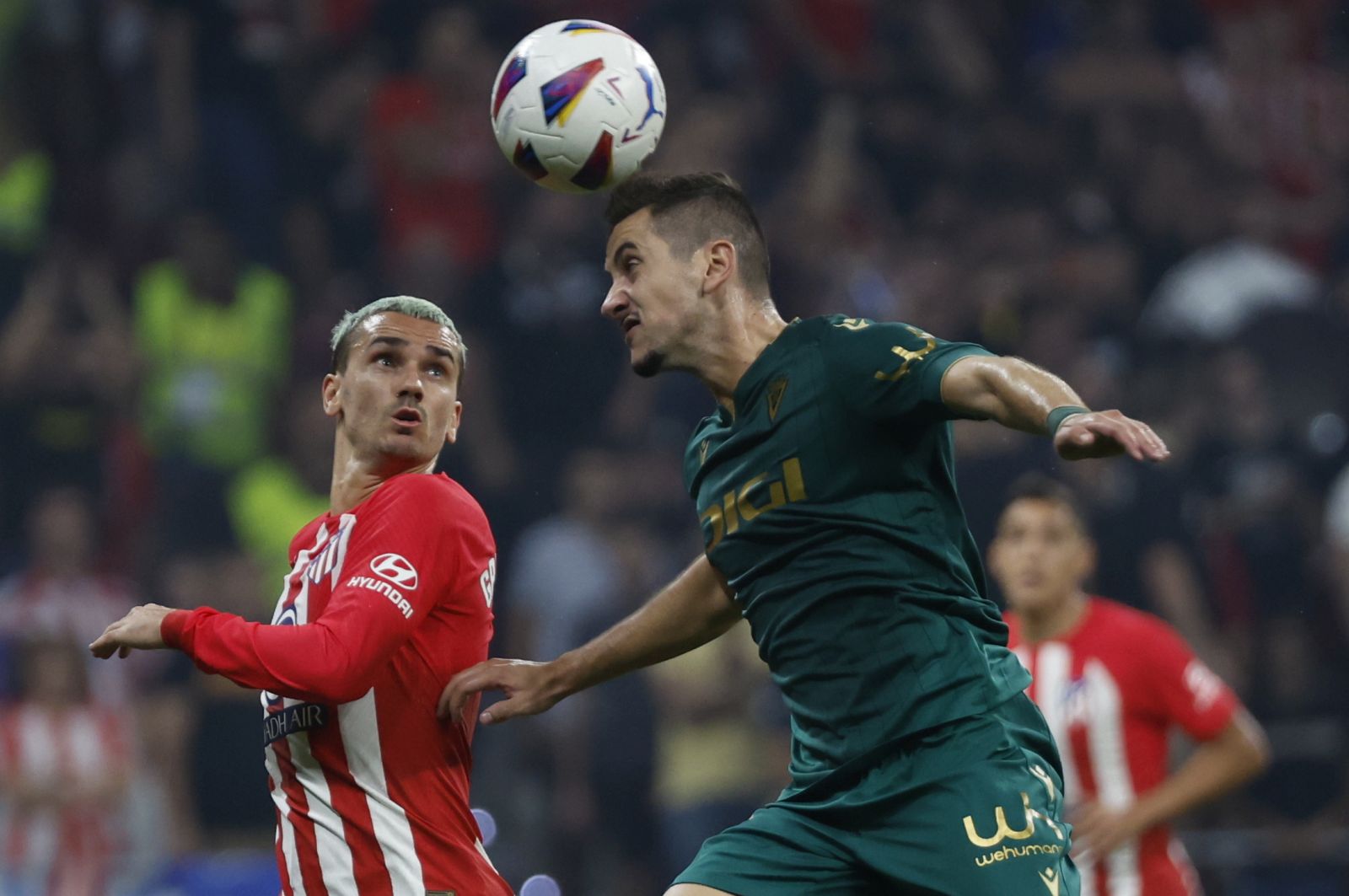 epa10894494 Cadiz CF's defender Joseba Zaldua (R) heads the ball against Atletico's Antoine Griezmann (L) during the Spanish LaLiga soccer match between Atletico de Madrid and Cadiz CF, in Madrid, Spain, 01 October 2023.  EPA/JUANJO MARTIN