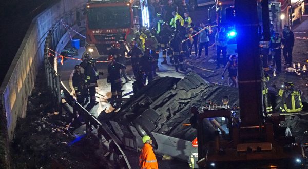 epa10898703 Firefighters work at the site where a passenger bus fell from an overpass ending up on railway tracks in Mestre, near Venice, Italy, late 03 October 2023 (issued 04 October 2023). At least 21 people died in the accident and 15 others were injured.  EPA/ANDREA MEROLA