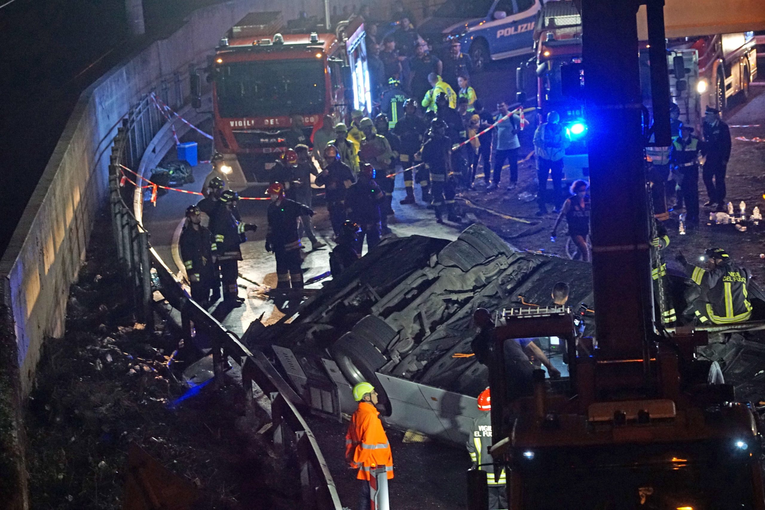 epa10898703 Firefighters work at the site where a passenger bus fell from an overpass ending up on railway tracks in Mestre, near Venice, Italy, late 03 October 2023 (issued 04 October 2023). At least 21 people died in the accident and 15 others were injured.  EPA/ANDREA MEROLA