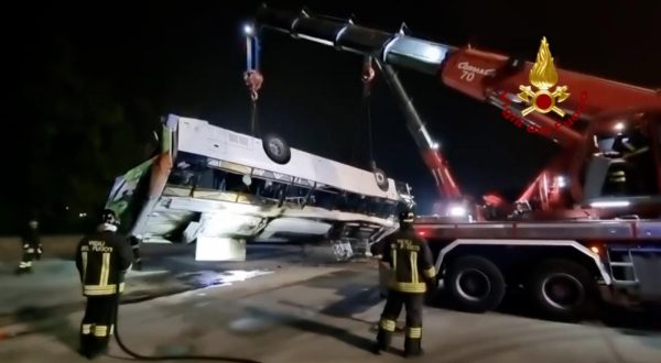 epa10898916 A handout photo made available by Vigili del Fuoco (Italy's Firefighters) shows the removal of the wreckage of a bus after it fell off an overpass the previous night, in Mestre, near Venice, Italy, early 04 October 2023. At least 21 people died in the accident on 03 October and 15 others were injured.  EPA/Vigili del Fuoco HANDOUT  HANDOUT EDITORIAL USE ONLY/NO SALES