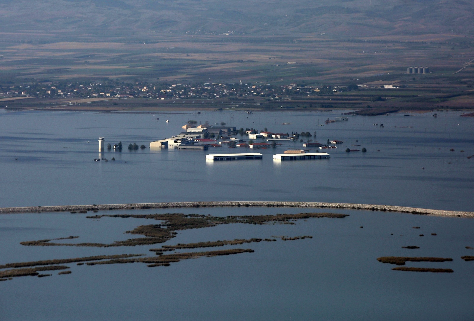 epa10902059 An aerial view shows flooded agricultural lands and facilities in the Thessalian plain, Greece, 05 October 2023.  European Commissioner for Agriculture Janusz Wojciechowski visited areas of Thessaly affected by the flooding caused by the recent destructive storms, Daniel and Elias, at the invitation of Rural Development and Foods Minister Lefteris Avgenakis. Wojciechowski visited farms in Thessaly to see the damage inflicted by floods and talk with flood victims.  EPA/ORESTIS PANAGIOTOU