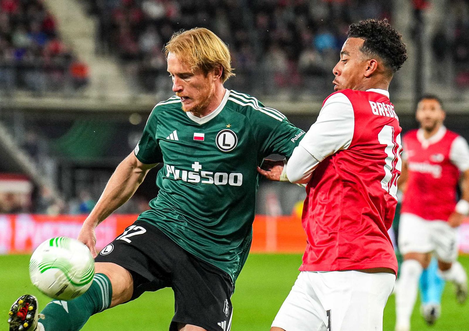 epa10902411 Radovan Pankov (L) of Legia and Myron van Brederode (R) of AZ in action during the UEFA Europa Conference League group stage match between AZ Alkmaar and Legia Warschau in Alkmaar, Netherlands, 05 October 2023.  EPA/Ed van de Pol