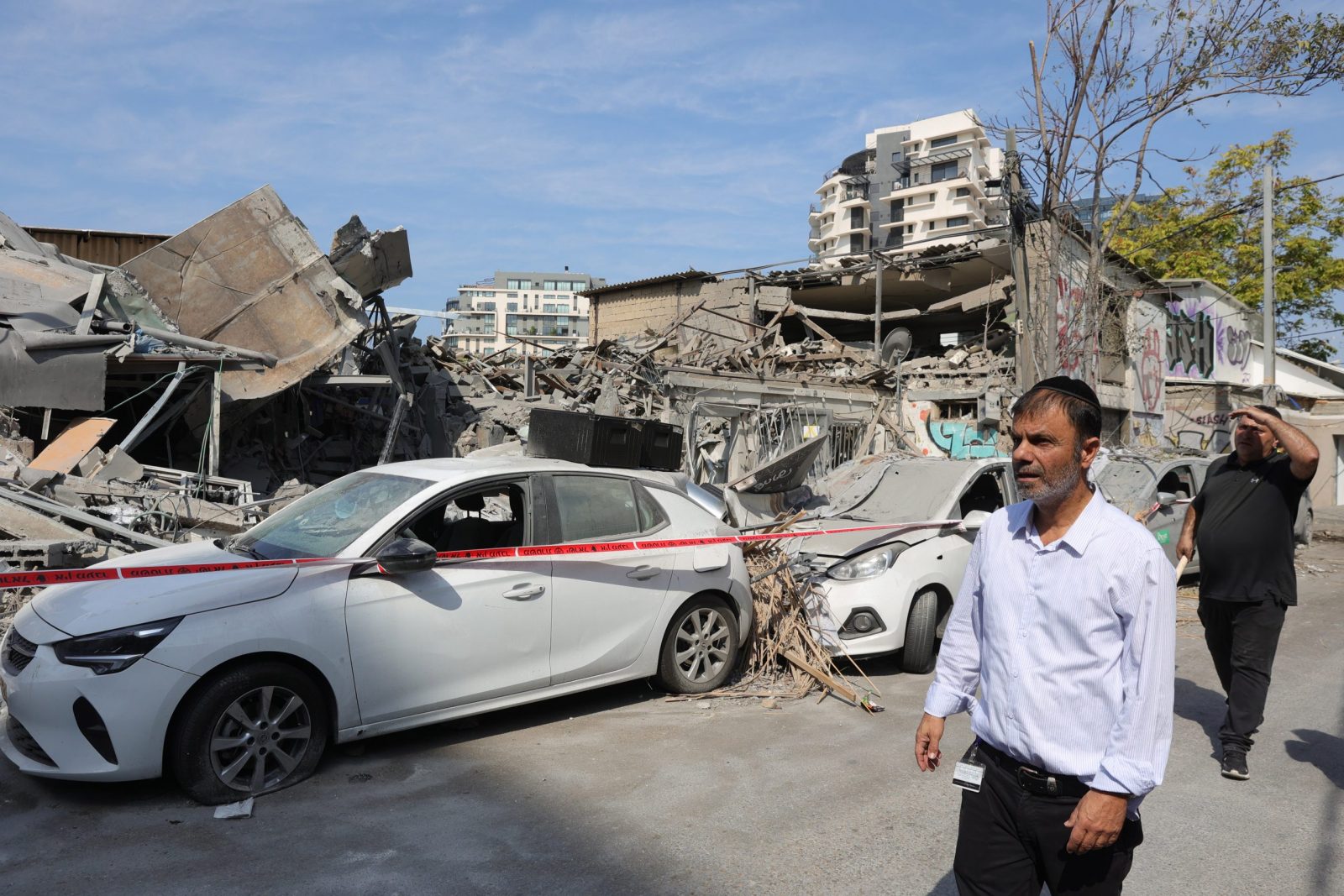 epa10906895 Residents view destroyed vehicles and structures in Tel Aviv, Israel, 08 October 2023, following overnight Hamas rocket attacks. Rocket barrages were launched from the Gaza Strip as of early 07 October in a surprise attack claimed by the Islamist movement Hamas. More than 300 Israelis were killed and over 1,000 left injured in the attacks, the Israeli foreign ministry said.  EPA/ABIR SULTAN