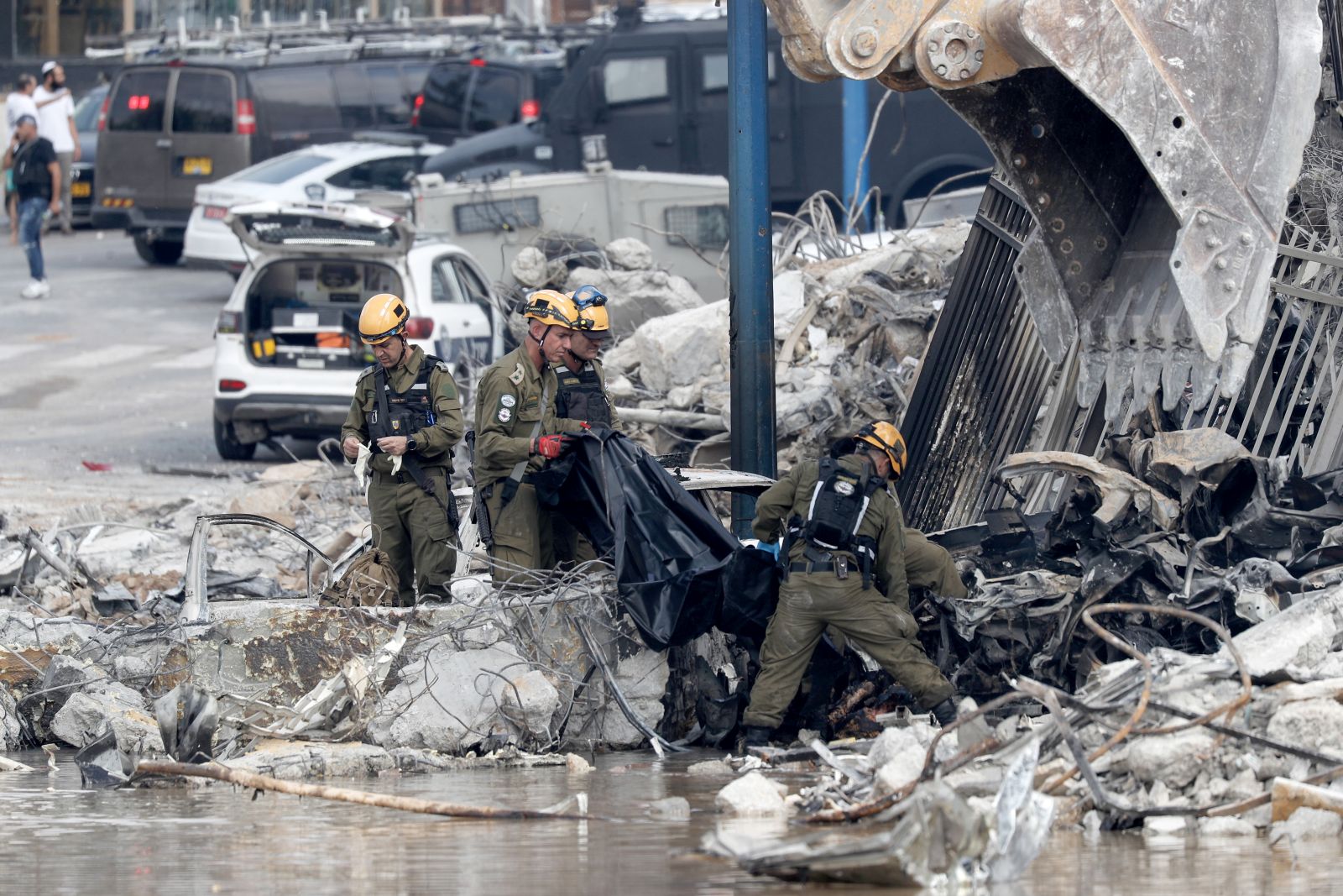 epa10907018 Israeli security forces remove a body outside the destroyed police station that was controlled by Hamas militants in the southern city of Sderot, close to the Gaza border, Israel, 08 October 2023. Rocket barrages were launched from the Gaza Strip as of early 07 October in a surprise attack claimed by the Islamist movement Hamas. More than 300 Israelis were killed and over 1,000 left injured in the attacks, the Israeli foreign ministry said.  EPA/ATEF SAFADI