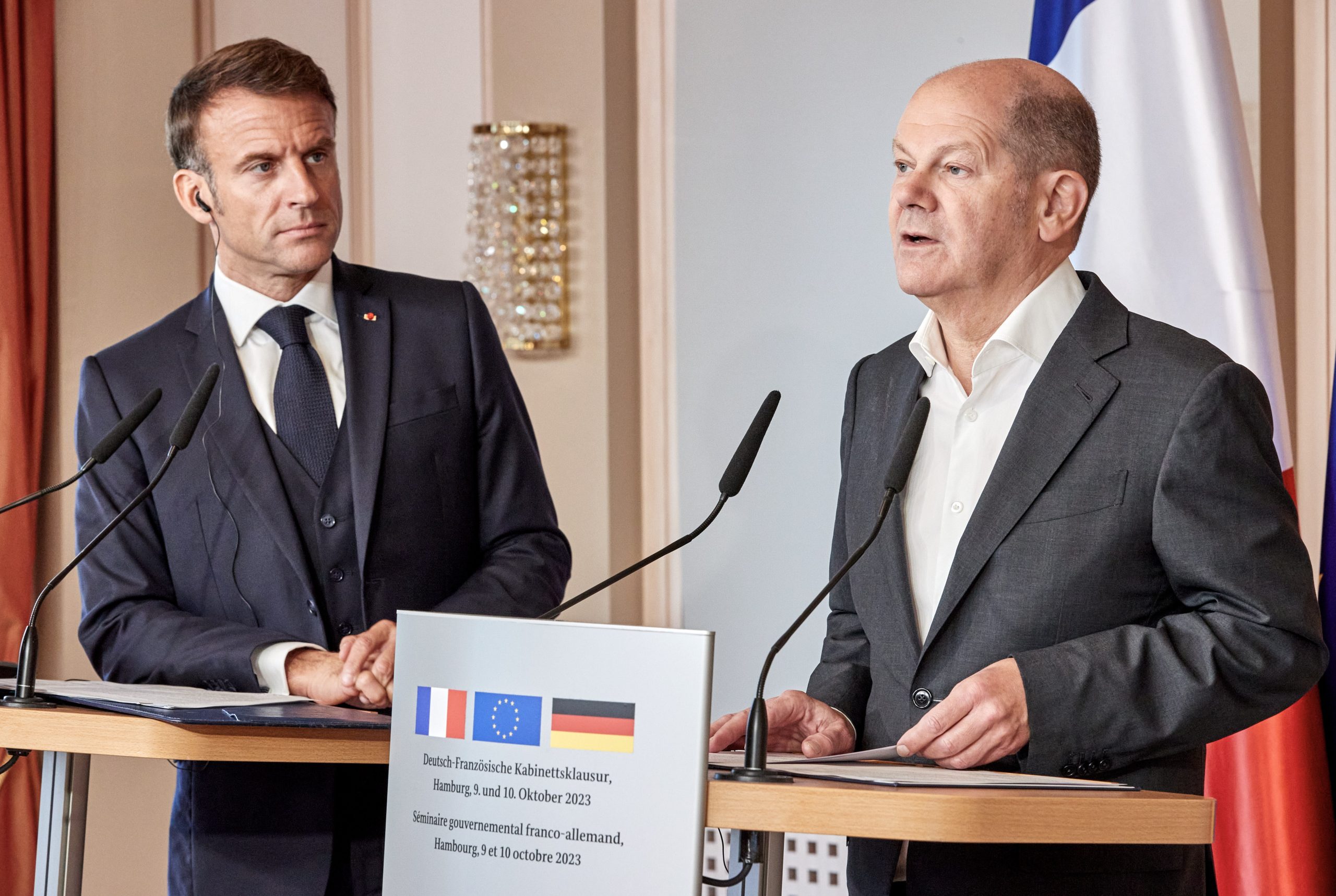 epa10911090 French President Emmanuel Macron (L) listens as German Chancellor Olaf Scholz (R) speaks during a joint press conference following a working session as part of a French-German cabinet meeting in Hamburg, Germany, 10 October 2023. French President Macron and German Chancellor Scholz will meet with their ministers in Hamburg from 9 to 10 October as part of a Franco-German joint cabinet meeting, aiming to increase the cooperation between the two countries.  EPA/GEORG WENDT / POOL *** Local Caption *** 20521743