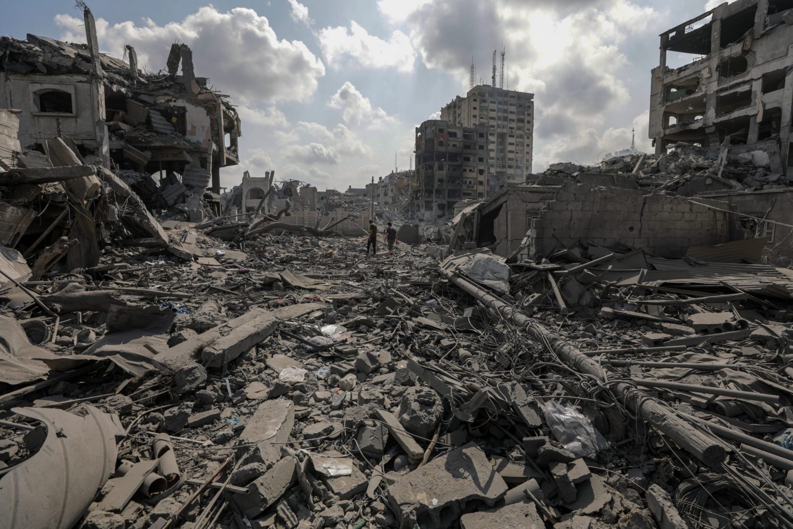 epa10911300 Palestinians walk among the rubble in the destroyed Al-Ramal neigbourhood following an Israeli air strike in Gaza City, 10 October 2023. More than 700 people have been killed and around 4,000 have been injured according to the Palestinian Ministry of Health, after Israel started bombing the Palestinian enclave in response to an attack carried out by the Islamist movement Hamas on 07 October. More than 3,000 people, including 1,500 militants from Hamas, have been killed and thousands injured in Gaza and Israel since 07 October, according to Israeli military sources and Palestinian officials.  EPA/MOHAMMED SABER