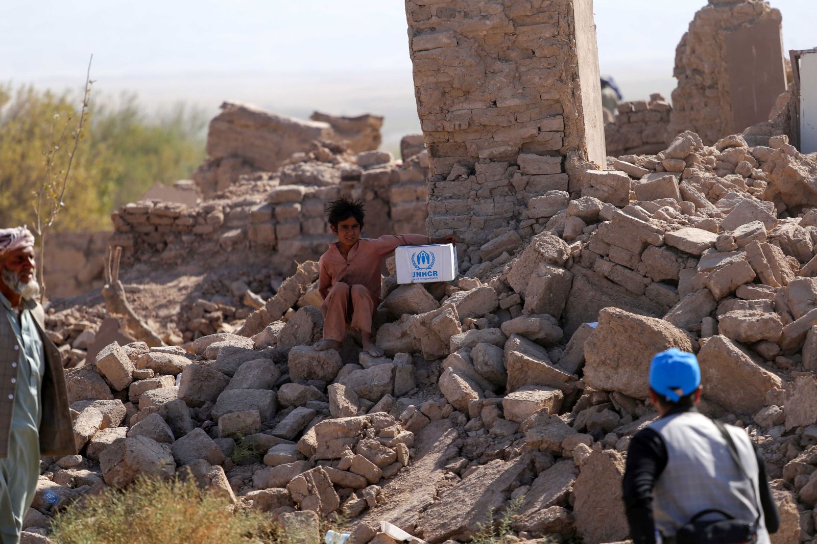 epa10911976 People affected by the earthquake sit on a rubble of damaged building in earthquake-hit  Zinda Jan district of Herat, Afghanistan, 10 October 2023. A 6.3-magnitude earthquake and the consecutive aftershocks that struck western Afghanistan during the weekend killed nearly 3,000, according to estimates by the government and nonprofit organizations. Over 2,000 people were wounded and 20 villages completely destroyed in the tremors.  EPA/SAMIULLAH POPAL