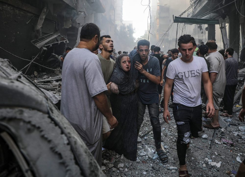 epaselect epa10919048 An injured woman is helped away from the site of an Israeli rocket attack in Al- Shati refugee camp in the west of Gaza City on, 14 October 2023. The Israeli Defense Force (IDF) on 13 October called for the evacuation of all civilians of northern Gaza ahead of an expected ground invasion. More than 1,300 Israelis have been killed and over 3,200 others injured, according to the IDF, after the Islamist movement Hamas launched an attack against Israel from the Gaza Strip on 07 October. More than 2,000 Palestinians have been killed and over 8,700 others injured in Gaza since Israel launched retaliatory air strikes, the Palestinian health ministry said.  EPA/MARTIN DIVISEK  EPA-EFE/MOHAMMED SABER