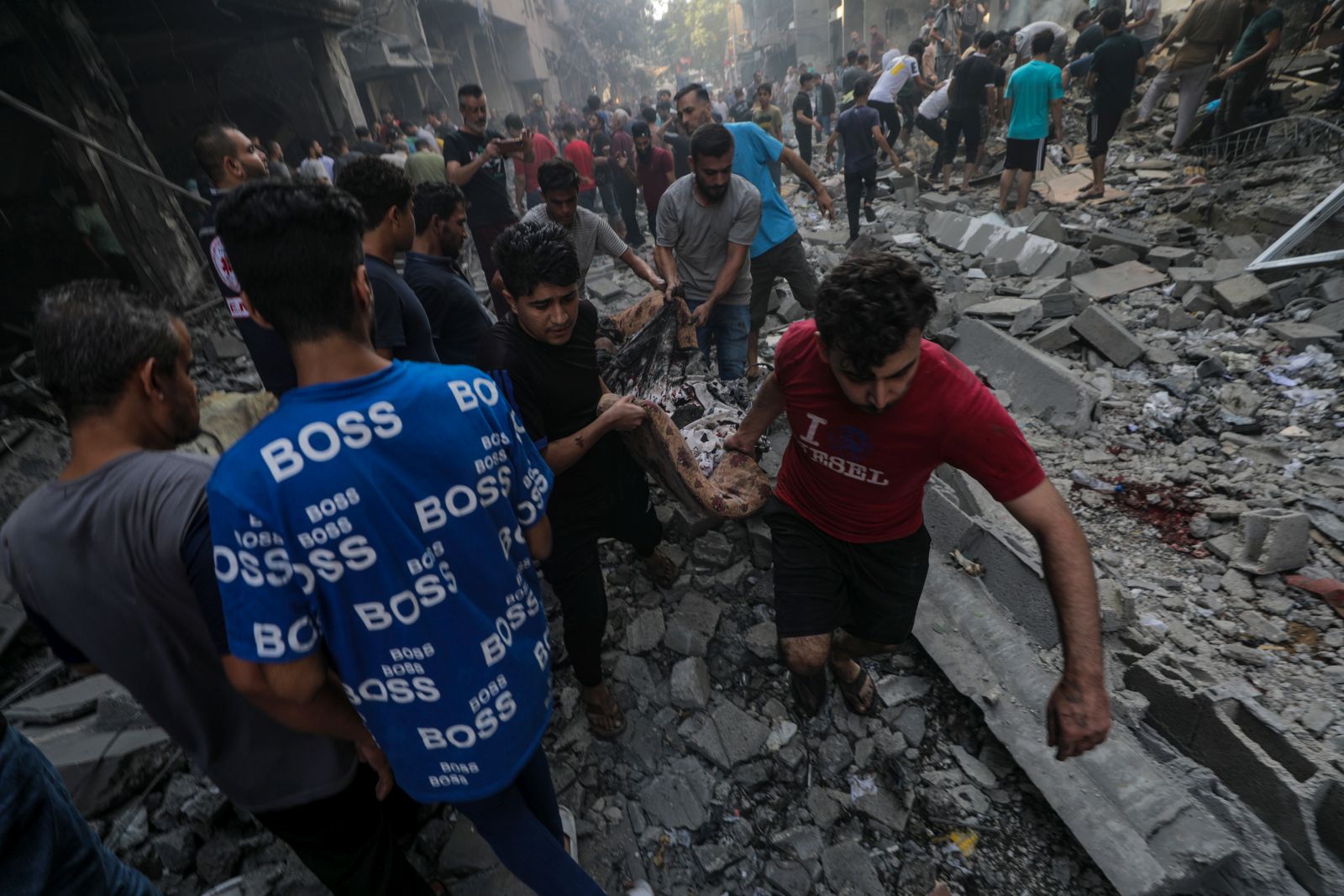 epa10919206 Men remove a body from the site of an Israeli rocket attack in Al-Shati refugee camp in the west of Gaza City on, 14 October 2023. The Israeli Defense Force (IDF) on 13 October called for the evacuation of all civilians of northern Gaza ahead of an expected ground invasion. More than 1,300 Israelis have been killed and over 3,200 others injured, according to the IDF, after the Islamist movement Hamas launched an attack against Israel from the Gaza Strip on 07 October. More than 2,000 Palestinians have been killed and over 8,700 others injured in Gaza since Israel launched retaliatory air strikes, the Palestinian health ministry said.  EPA/MOHAMMED SABER