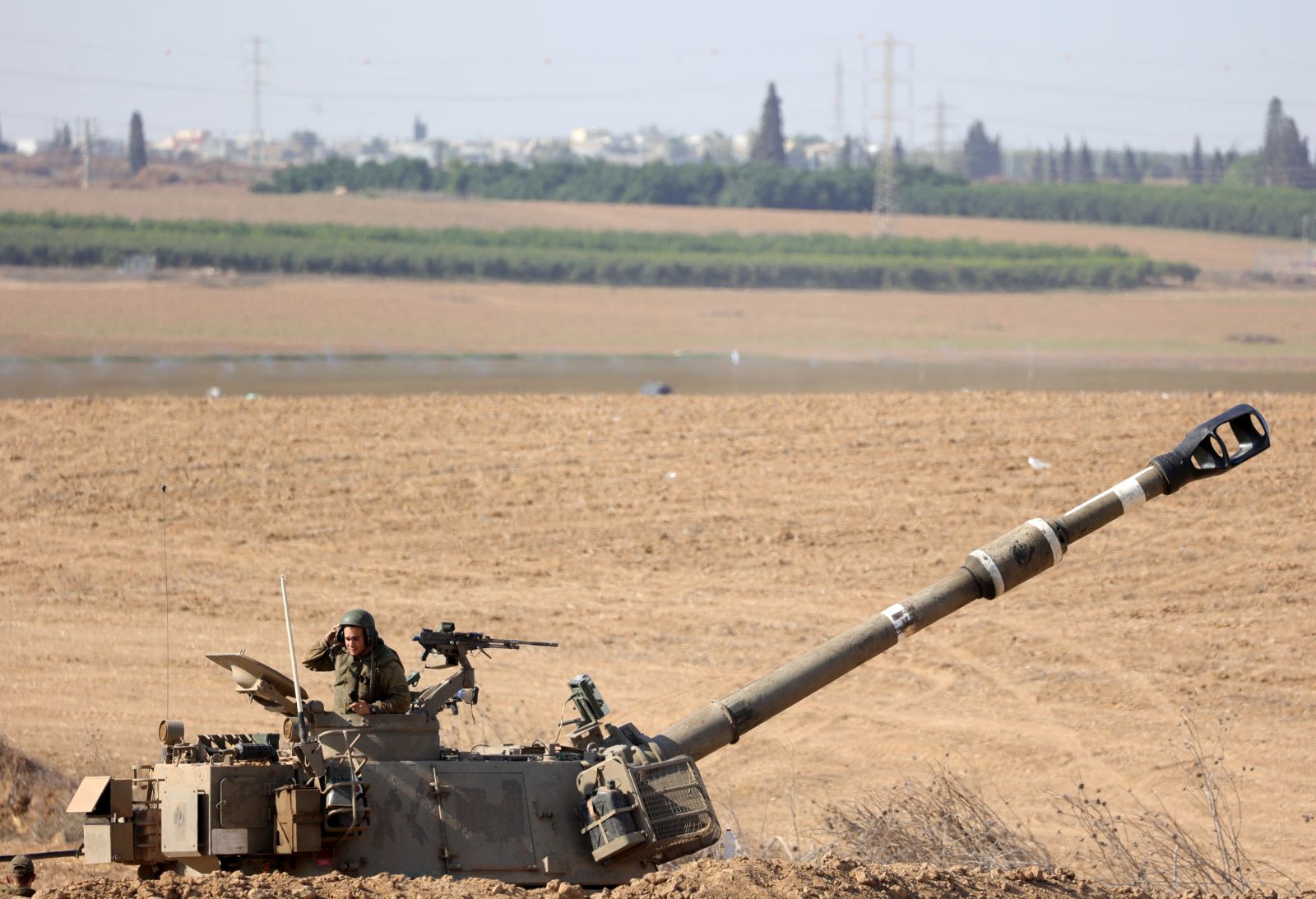 epa10919991 An Israeli soldier next to a machine gun on top of tank turret at an area along the border with Gaza, southern Israel, 15 October 2023. The Israel Defense Force (IDF) on 14 October announced they are increasing readiness and preparing to 'implement a wide range of operational offensive plans', including combined and coordinated strikes by land, sea and air. Israel has called for the evacuation of all civilians of northern Gaza ahead of an expected ground invasion. More than 1,300 Israelis have been killed and over 3,200 others injured, according to the IDF, after the Islamist movement Hamas launched an attack against Israel from the Gaza Strip on 07 October. More than 2,300 Palestinians have been killed and over 9,000 others injured in Gaza since Israel launched retaliatory air strikes, the Palestinian health ministry said.  EPA/ABIR SULTAN
