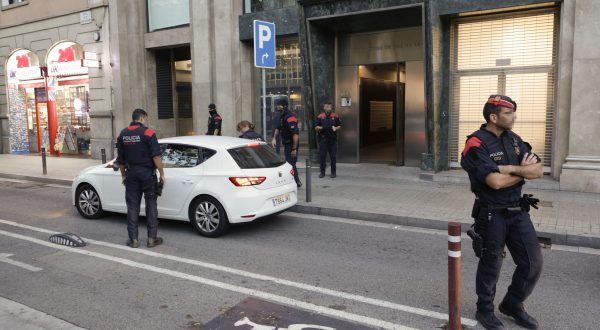 epa10923063 Officers of the Catalonia's regional police Mossos d'Esquadra stand guard in front of a building in Barcelona, Spain, 17 October 2023, as part of a joint operation with Italian Police and Europol, against an Italian drug trafficking criminal group, that operates in Spain.  EPA/QUIQUE GARCIA