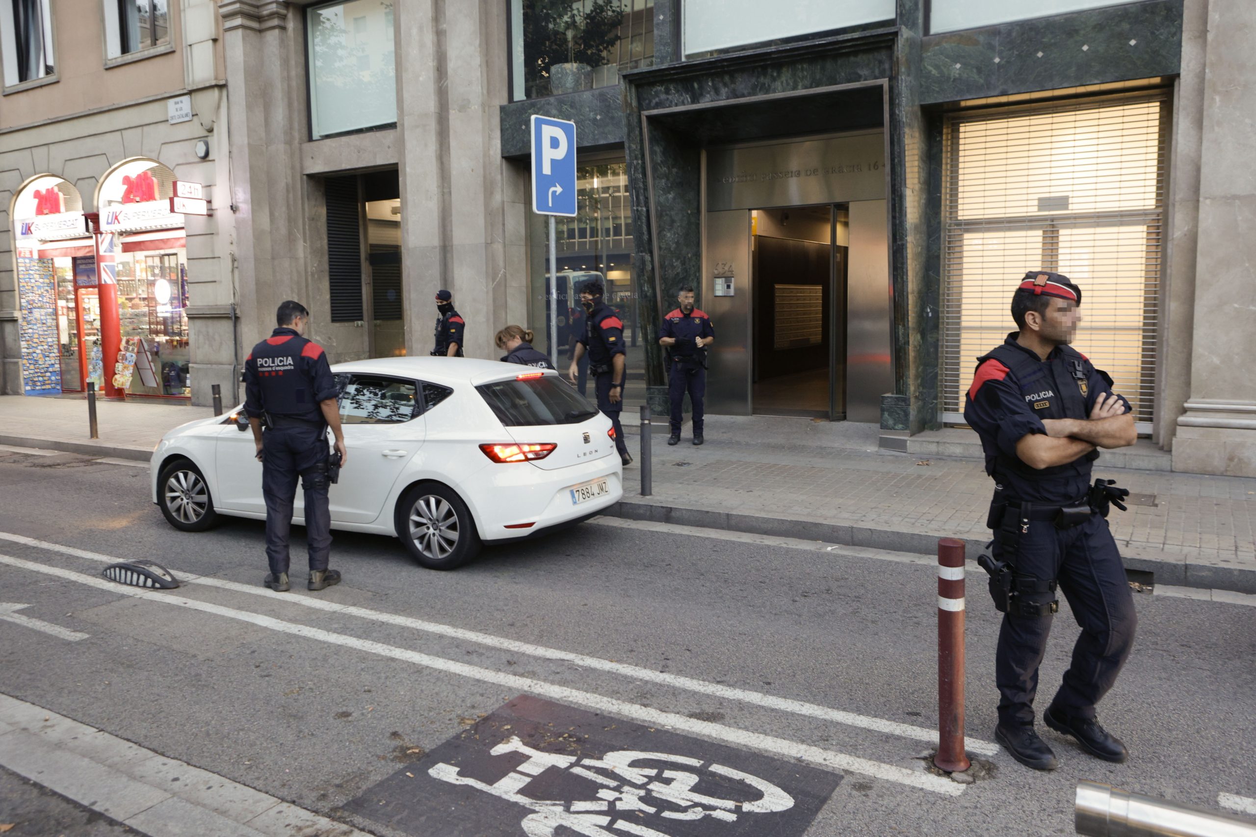 epa10923063 Officers of the Catalonia's regional police Mossos d'Esquadra stand guard in front of a building in Barcelona, Spain, 17 October 2023, as part of a joint operation with Italian Police and Europol, against an Italian drug trafficking criminal group, that operates in Spain.  EPA/QUIQUE GARCIA