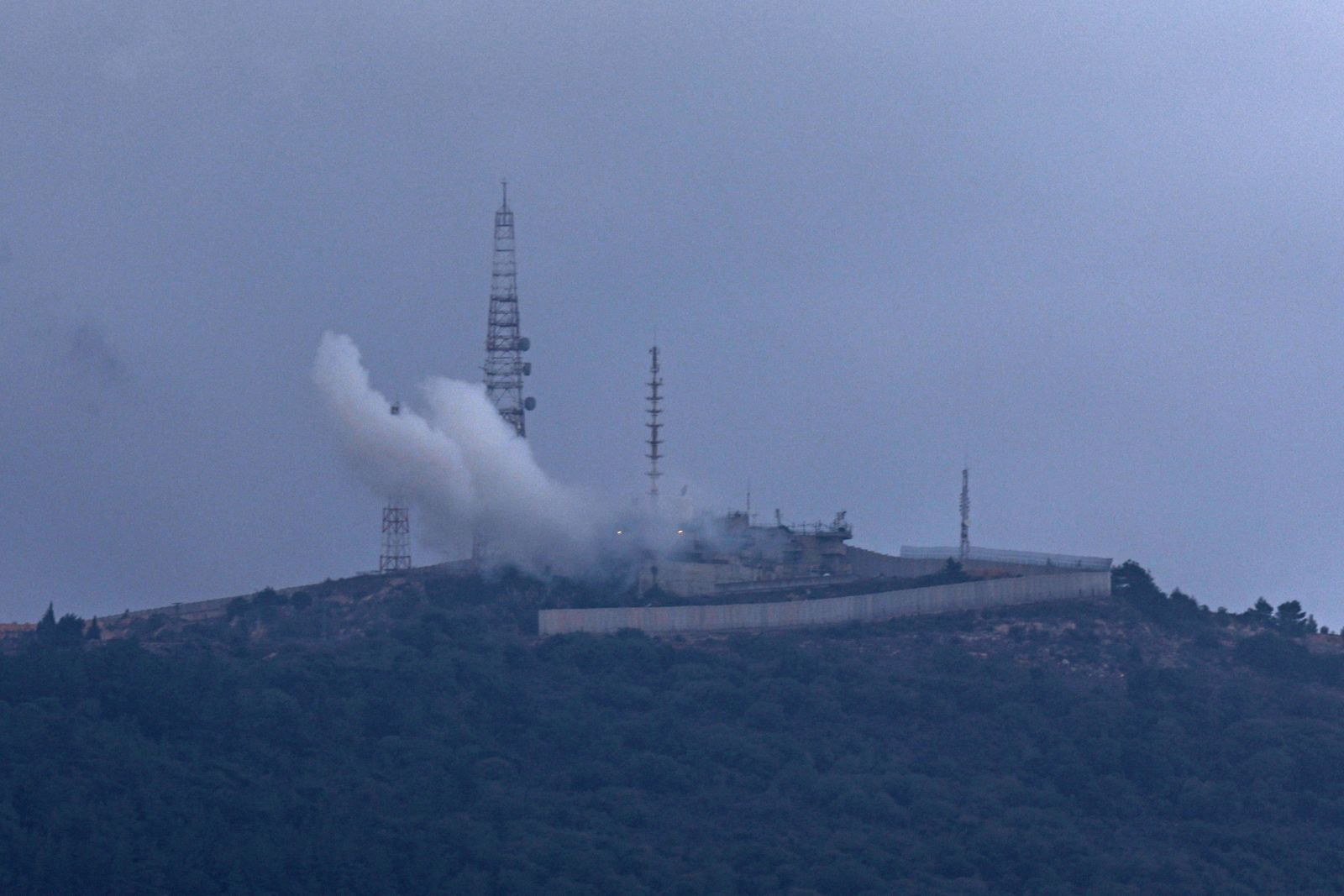 epa10927466 Smoke rises from an area of the Israeli army base located next to Kibbutz Manara due to a rocket launched from the Lebanese side of the border, northern Israel, 19 October 2023. The Israeli army announced they identified 20 rocket launches from Lebanese territory into Israel on 19 October. Tensions remain high on the Lebanon-Israel border following an escalation in fighting between the two countries as the Israeli-Palestinian conflict flared up.  EPA/ATEF SAFADI