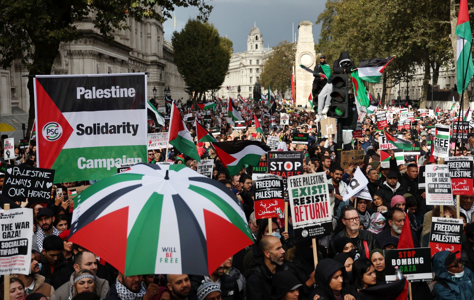 epa10930801 Pro-Palestinian protesters hold placards and show Palestinian colors on a march through the British capital during a demonstration for the Palestinian people, in London, Britain, 21 October 2023. Thousands of Israelis and Palestinians have died since the militant group Hamas launched an unprecedented attack on Israel from the Gaza Strip on 07 October 2023, and the Israeli strikes on the Palestinian enclave which followed it.  EPA/ANDY RAIN