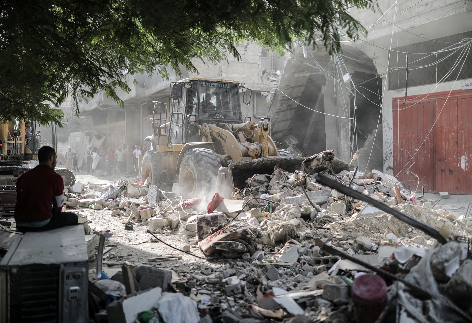 epa10932896 A man looks on as an excavator removes the rubble of a residential building that was leveled following an Israeli airstrike on Khan Younis refugee camp, southern Gaza Strip, 22 October 2023. More than 4,500 Palestinians and 1,400 Israelis have been killed, according to the Israel Defense Forces (IDF) and the Palestinian health authority, since Hamas militants launched an attack against Israel from the Gaza Strip on 07 October.  EPA/HAITHAM IMAD