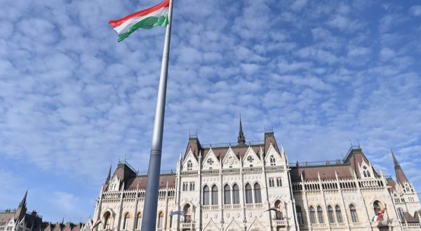 epa10933955 The Hungarian national flag flies after it was raised in front of the Parliament building during a state commemoration ceremony to mark the 67th anniversary of the outbreak of the Hungarian revolution and war of independence against communist rule and the Soviet Union in 1956 in Budapest, Hungary, 23 October 2023.  EPA/NOEMI BRUZAK HUNGARY OUT