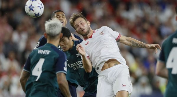 epa10937086 Sevilla's Ivan Rakitic (R) in action against Arsenal's Takehiro Tomiyasu (C) during the UEFA Champions League group B soccer match between Sevilla FC and Arsenal, in Seville, southern Spain, 24 October 2023.  EPA/Jose Manuel Vidal