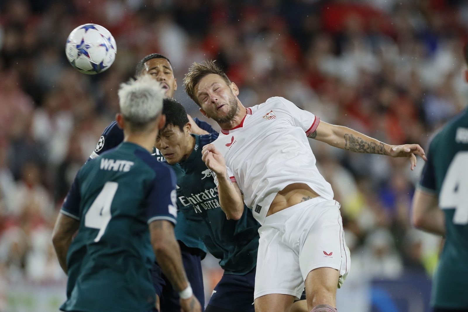 epa10937086 Sevilla's Ivan Rakitic (R) in action against Arsenal's Takehiro Tomiyasu (C) during the UEFA Champions League group B soccer match between Sevilla FC and Arsenal, in Seville, southern Spain, 24 October 2023.  EPA/Jose Manuel Vidal