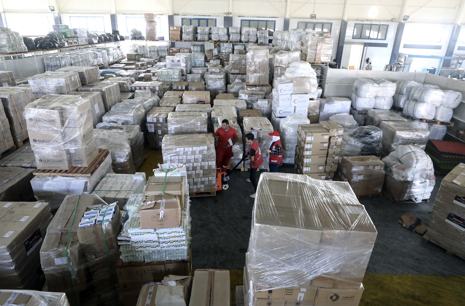 epa10938275 Egyptian Red Crescent Society employees and volunteers handle humanitarian aid bound for Palestinians in the Gaza Strip, at a warehouse in Arish, Egypt, 25 October 2023. International mediators continued on 25 October to push for the passage of more aid into Gaza and the exit of foreign nationals fleeing the conflict. The international humanitarian aid convoys are mostly stationed on the road between the town of Arish and the Rafah border crossing 50 km away. Fifty Four aid trucks have so far made their way into the Gaza strip through Egypt's border according to aid organizations, while various UN agencies asked for more to be allowed in, as most of the inhabitants of Gaza have been displaced to the southern part of the strip and lack access to food, electricity and medical supplies. More than 5,500 Palestinians and 1,400 Israelis have been killed according to the IDF and Palestinian health ministry, after Hamas militants launched an attack against Israel from the Gaza Strip on 07 October and the Israeli operations in Gaza and the West Bank which followed it.  EPA/KHALED ELFIQI