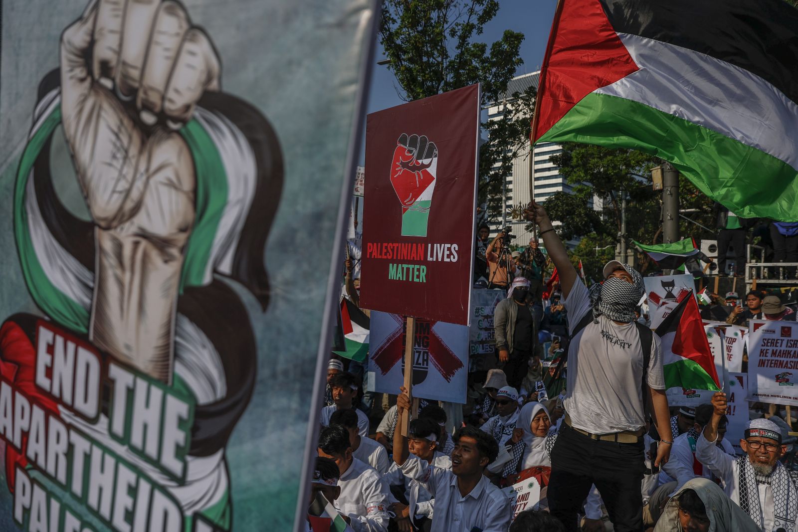 epa10944072 People hold placards and Palestinian flags during a rally in solidarity with the Palestinians, outside the US embassy in Jakarta, Indonesia, 28 October 2023. Thousands of people staged a rally calling the world leaders to stop the violence in Gaza. Thousands of Israelis and Palestinians have died since the militant group Hamas launched an unprecedented attack on Israel from the Gaza Strip, leading to Israeli retaliation strikes on the Palestinian enclave.  EPA/MAST IRHAM