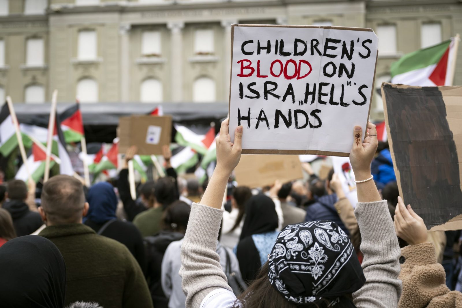 epa10945101 Protesters hold Palestinian flags and placards during an authorized rally in solidarity with Palestine, front of the Federal Palace, at the Federal square, in Bern, Switzerland, 28 October 2023. Thousands of Israelis and Palestinians have died since the militant group Hamas launched an unprecedented attack on Israel from the Gaza Strip on 07 October, and the Israeli strikes on the Palestinian enclave which followed it.  EPA/ANTHONY ANEX