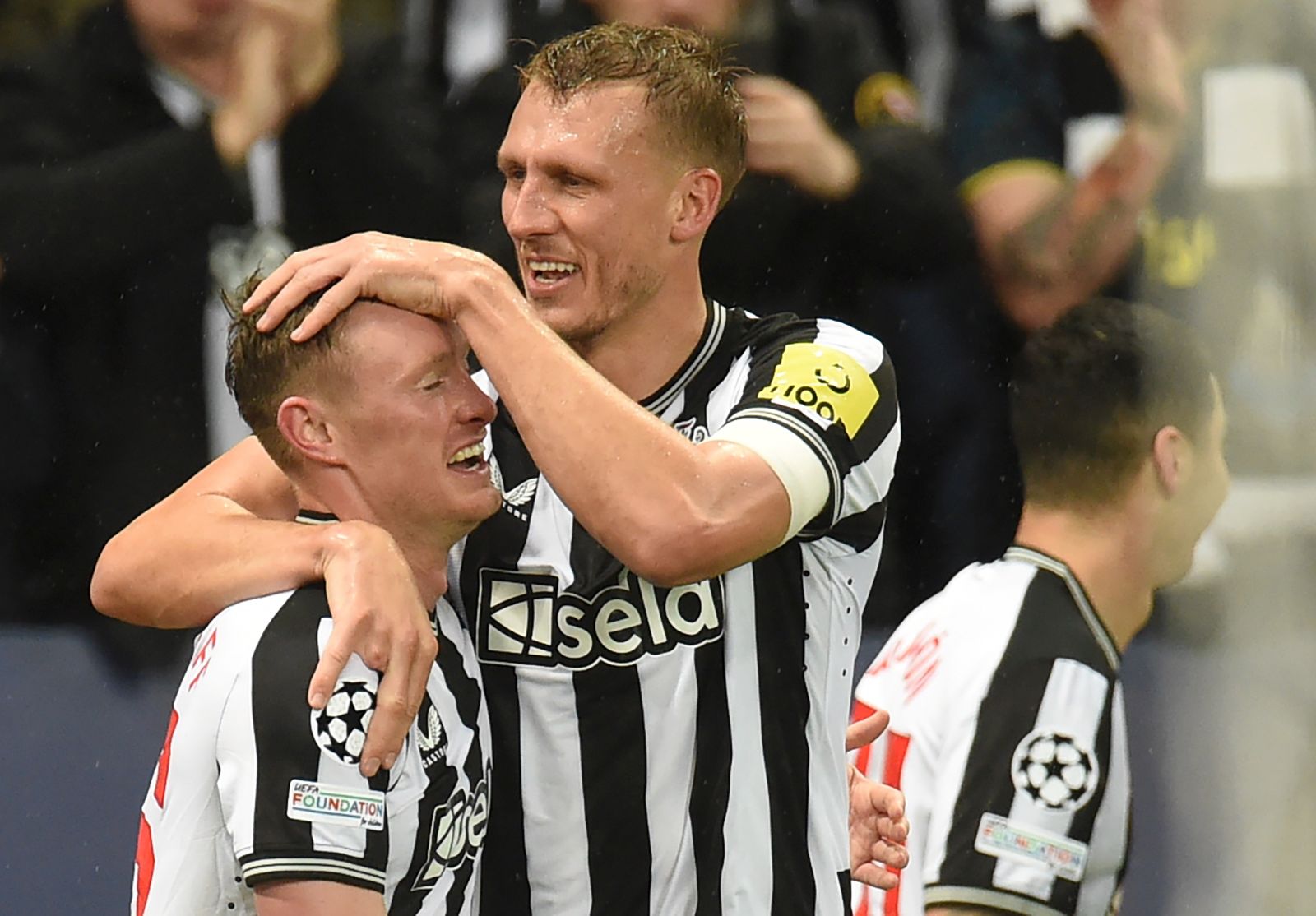 epa10901225 Sean Longstaff (L) of Newcastle celebrates with teammate Dan Burn after scoring the 3-0 during the UEFA Champions League Group F match between Newcastle United and Paris Saint-Germain in Newcastle, Britain, 04 October 2023.  EPA/PETER POWELL