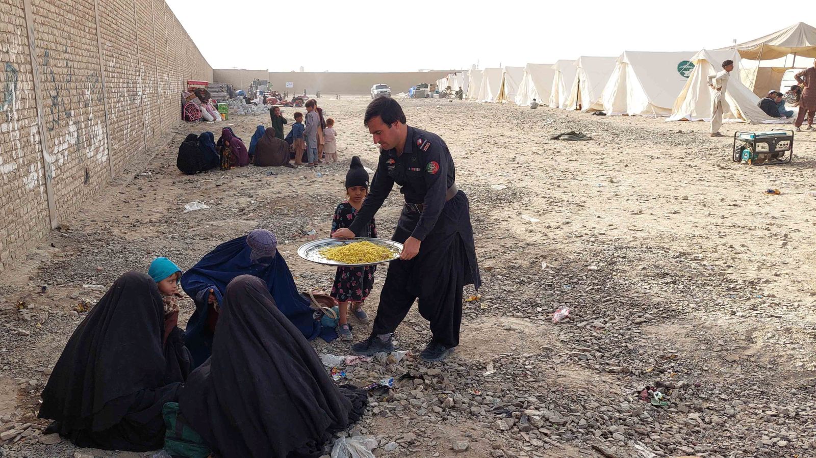epa10953961 Afghan refugees receive food as they stay at holding camps for verification after the Pakistani government's deadline to expel undocumented immigrants passed, near the Afghan border in Chaman, Pakistan, 02 November 2023. Pakistan is expected to implement its plan to expel undocumented immigrants as the deadline for them to leave the country expired. The move particularly affects the millions of Afghan refugees who had fled their homeland, many of them driven by decades of armed conflict and the return to power of the Taliban. Since the Pakistani authorities announced the 31 October deadline, a huge migratory flow has been recorded on the porous border between Pakistan and Afghanistan. According to official data, about 4.4 million Afghans are living in the country, of which 1.7 million are not registered.  EPA/AKHTER GULFAM
