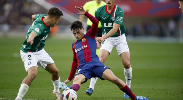 epa10971834 FC Barcelona's midfielder Pedri (C) in action against Alaves' defender Andoni Gorosabel (L) during the Spanish LaLiga soccer match between FC Barcelona and Deportivo Alaves, in Barcelona, Spain, 12 November 2023.  EPA/Alberto Estevez