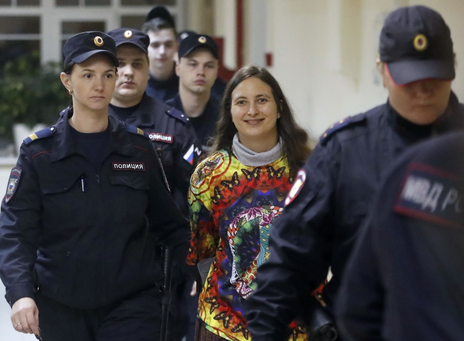 epa10973384 Russian artist and musician Sasha Skochilenko (C), 33, is escorted by police officers to the courtroom for a hearing in the Vasileostrovsky district court in St. Petersburg, Russia, 13 November 2023. Skochilenko was arrested in April 2022 and faces charges of spreading false information about the army after replacing supermarket price tags with slogans protesting against Russia's military operation in Ukraine.  EPA/ANATOLY MALTSEV