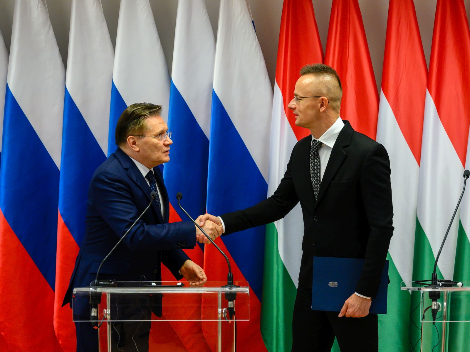 epa10974546 CEO of the Russian State Atomic Energy Corporation Rosatom, Alexey Likhachev (L) and Hungarian Minister of Foreign Affairs and Trade Peter Szijjarto shake hands during a press conference after they signed a construction schedule plan for 2024 in Paks, central Hungary, 14 November 2023. Szijjarto said that two new reactor blocks will start operating in the early 2030s. The investment aims to increase the capacity of Hungary's only nuclear plant, which already has four reactors that were built between 1982 and 1987. The plant, situated near the town of Paks, currently generates about half of the country's electricity. Rosatom is in charge of the Paks II project, which began in early 2014 by an agreement between governments to build two more reactors at the Paks nuclear factory, both provided by Rosatom.  EPA/TAMAS VASVARI HUNGARY OUT