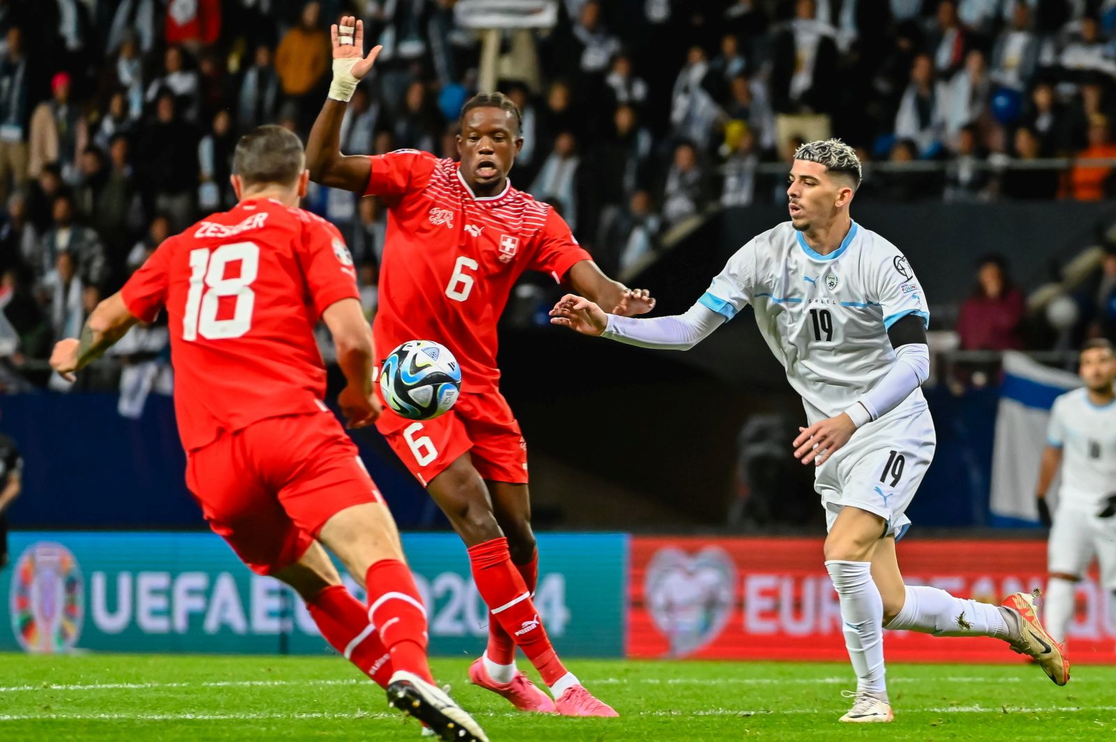 epa10977137 Dor Turgeman (R) of Israel fights for the ball with Denis Zakaria (C) of Switzerland during the UEFA Euro 2024 qualifying group I soccer match between Israel and Switzerland at Pancho Arena in Felcsut, Hungary, 15 November 2023.  EPA/Tamas Vasvari HUNGARY OUT