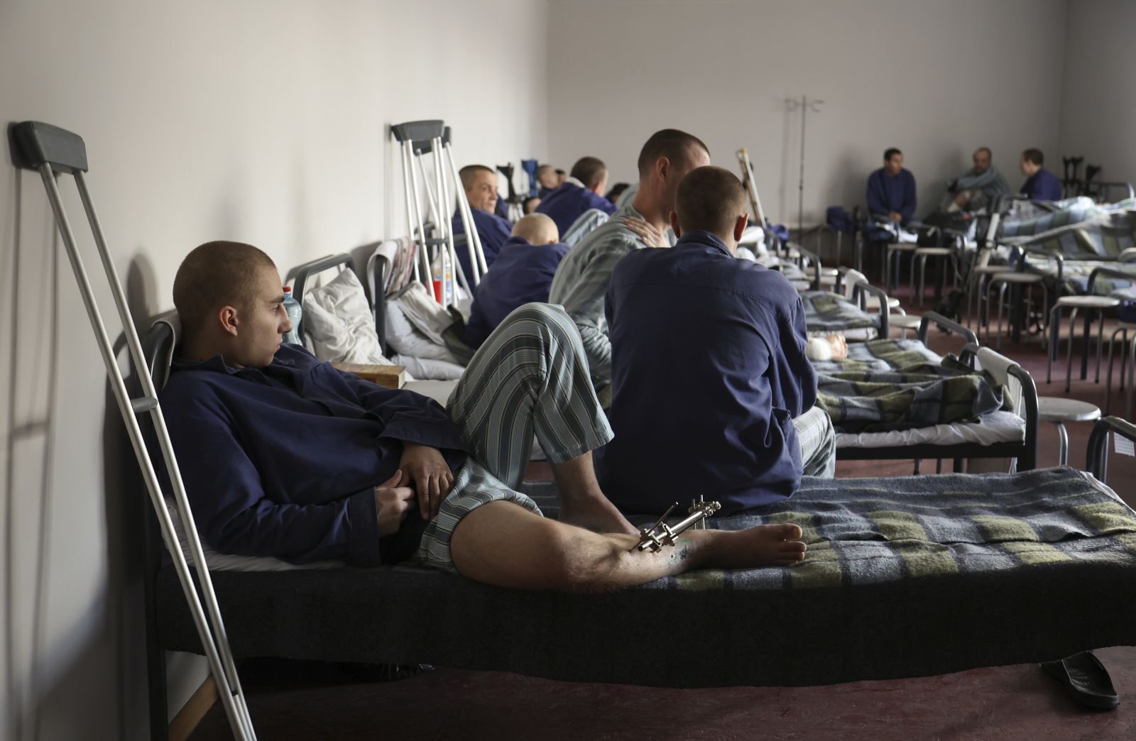 epa10979274 An injured Russian prisoner of war sits on a bed inside a detention center at an undisclosed location in the Lviv region, western Ukraine, 16 November 2023. Russia and Ukraine have been accusing each other of abusing and mistreating their respective prisoners of war, prompting a UN investigation in early 2023. A new camp will be opened for Russian prisoners of war in Ukraine due to the large number of them, the head of the Ministry of Justice, Denys Malyuska, announced 16 November. About 10,000 UAH (~250 EUR) per month are spent on the maintenance of one Russian soldier captured by Ukraine, the Ministry of Justice reported in the spring of 2023. Russian troops entered Ukrainian territory in February 2022, starting a conflict that has provoked destruction and a humanitarian crisis.  EPA/YAKIV LIASHENKO  ATTENTION: This Image is part of a PHOTO SET