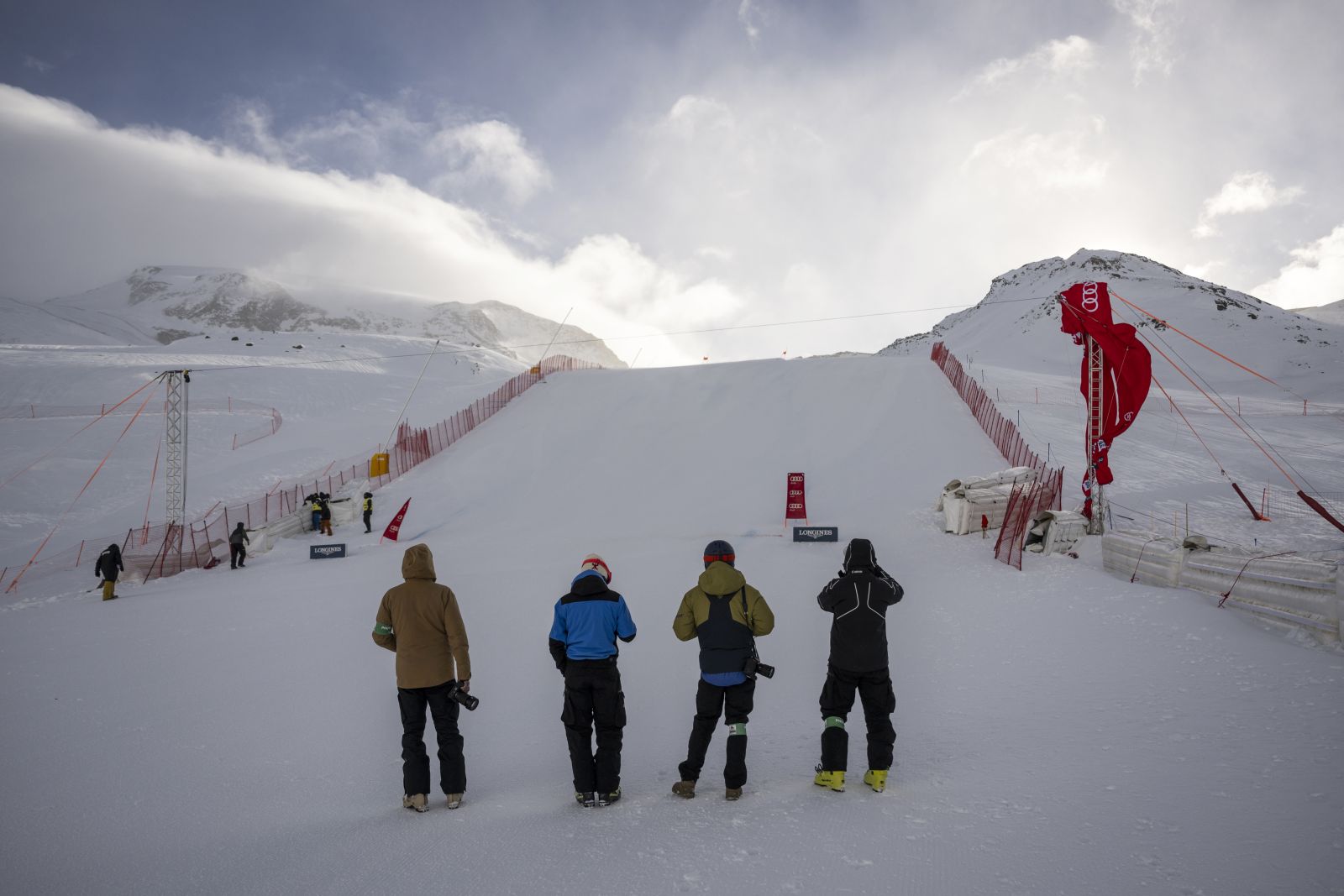 epa10982035 Press photographers standing in the finish area wait for the race to start, ahead of the women's downhill race on the new ski course 'Gran Becca' at the Alpine Skiing FIS Ski World Cup Zermatt-Cervinia, in Cervinia, Italy, 18 November 2023. Due to heavy wind the race was later cancelled.  EPA/ALESSANDRO DELLA VALLE