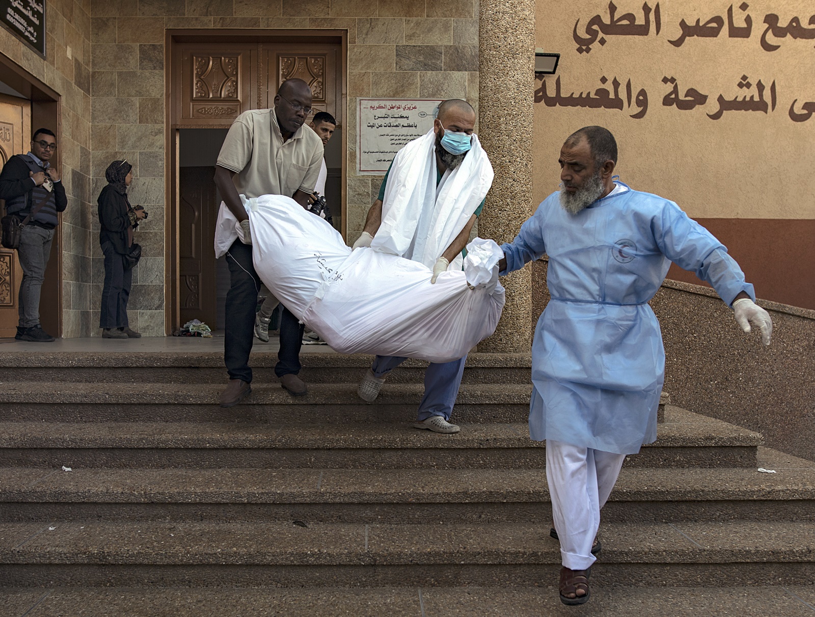 epa10982099 Medical facility workers carry a body of a Palestinian killed in an overnight airstrike on a house in Southern Gaza, amid the ongoing Israeli-Hamas conflict, at the Nasser Hospital in Khan Younis, southern Gaza Strip, 18 November 2023. More than 11,400 Palestinians and at least 1,200 Israelis have been killed, according to the Israel Defense Forces (IDF) and the Palestinian health authority, since Hamas militants launched an attack against Israel from the Gaza Strip on 07 October, and the Israeli operations in Gaza and the West Bank which followed it.  EPA/HAITHAM IMAD