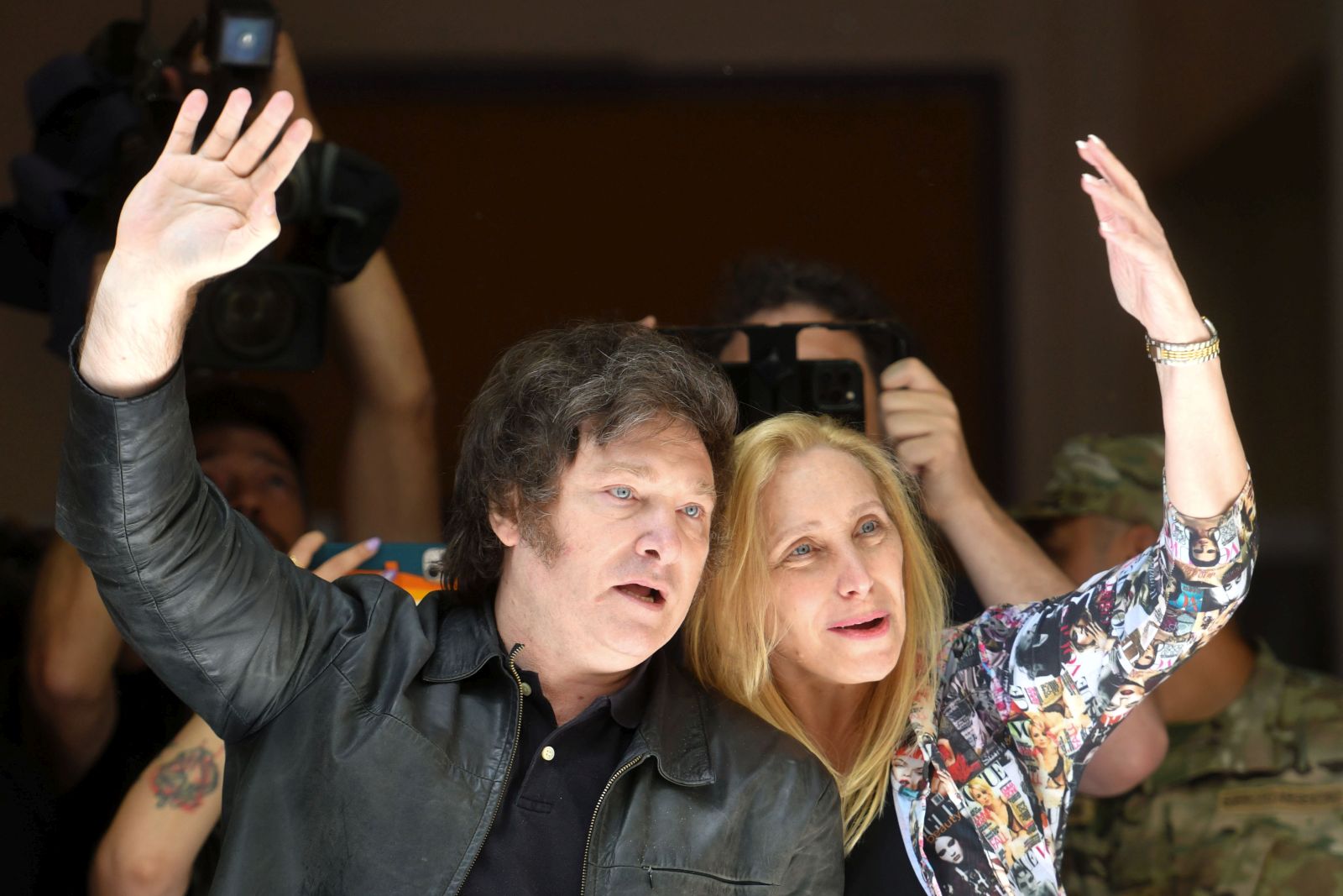 epa10985242 Argentina's presidential candidate for La Libertad Avanza (far-right), Javier Milei (L), and his sister Karina Milei (R) greet supporters after voting in Buenos Aires, Argentina, 19 November 2023. Milei said he was 'calm' and 'satisfied' after voting  in the ballot between him and the pro-government candidate, Sergio Massa, despite the 'campaign of fear' that, he said, his rival made against him. The polling stations in Argentina were opened for the second round of the presidential elections, where the next President and vice president will be elected.  EPA/ENRIQUE GARCIA MEDINA