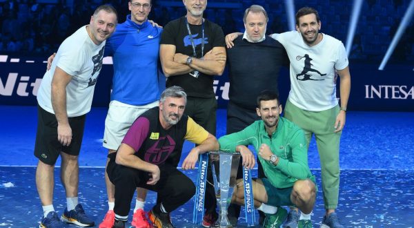 epa10985382 Novak Djokovic of Serbia (bottom R), his coaches Goran Ivanisevic (bottom L) and Marco Panichi (R), and team members pose with the trophy after winning his singles finals match against Jannik Sinner of Italy at the Nitto ATP Finals tennis tournament in Turin, Italy, 19 November 2023.  EPA/ALESSANDRO DI MARCO