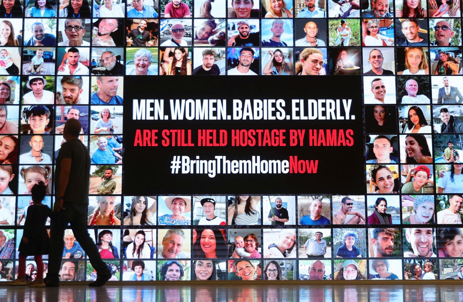 epaselect epa10988033 People walk past a billboard showing photos of people abducted by Hamas, at the Tel Aviv museum in Tel Aviv, Israel, 21 November 2023. Israeli Prime Minister Benjamin Netanyahu will convene his war cabinet this evening to approve a deal for the release of hostages. According to the Israeli army 236 Israelis including 40 children are held in captivity in Gaza. More than 12,500 Palestinians and at least 1,200 Israelis have been killed, according to the Israel Defense Forces (IDF) and the Palestinian health authority, since Hamas militants launched an attack against Israel from the Gaza Strip on 07 October, and the Israeli operations in Gaza and the West Bank which followed it.  EPA/ABIR SULTAN