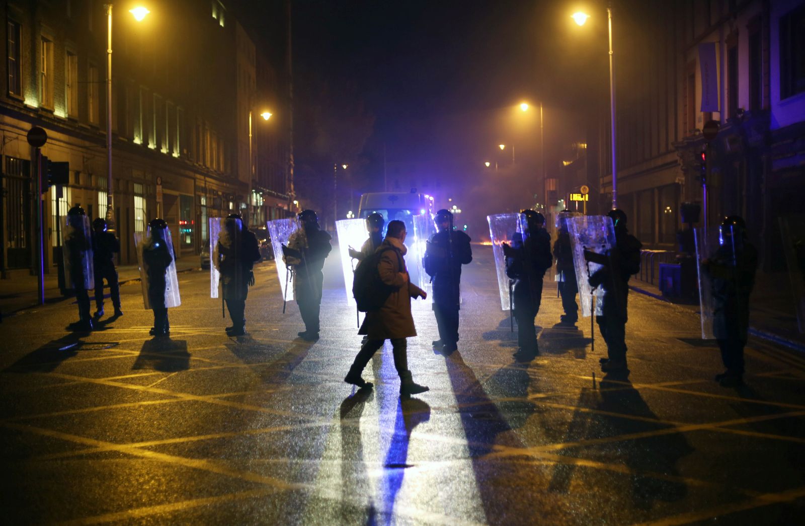 epaselect epa10991656 A person walks past Garda police officers in riot gear on O'Connell Street after violence broke out following a knife attack earlier in the day in which five people were injured, including three young children, in Dublin, Ireland, 23 November 2023. A Garda spokesperson reported that the injured include an adult male, an adult female and three young children. Taoiseach Leo Varadkar has confirmed that the gardai have detained a suspect. Garda and local politicians have called for calm after violence broke out.  EPA/MOSTAFA DARWISH